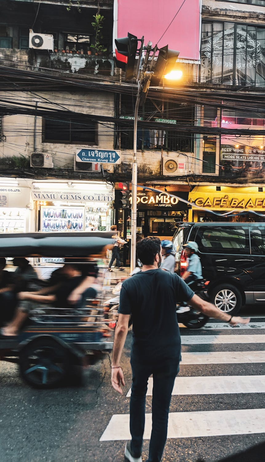 a guy casually crossing the sidewalk in Bangkok