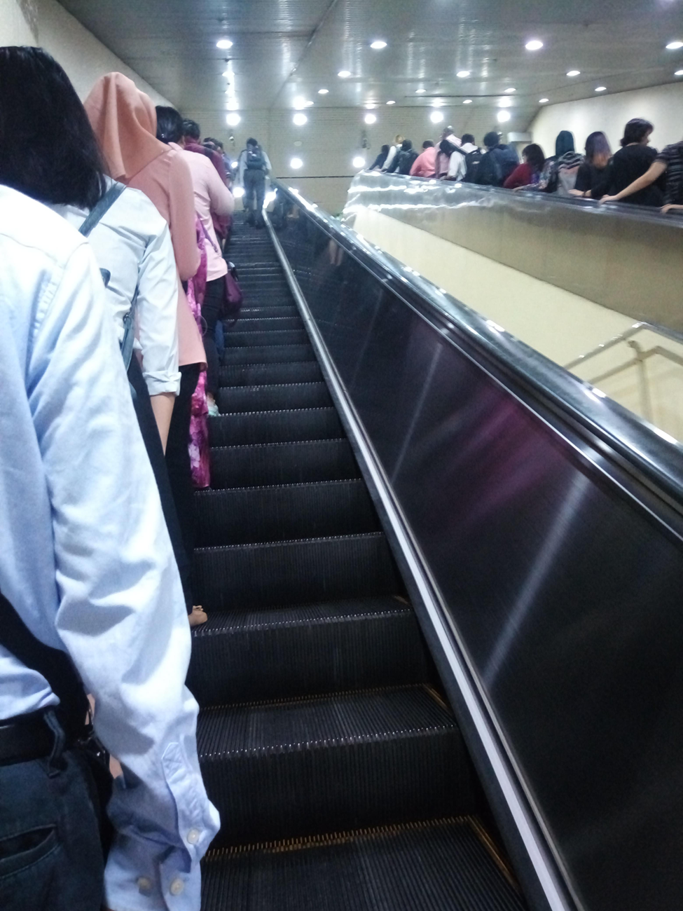 People queue-ing to the left of the elevator, as opposed to the right