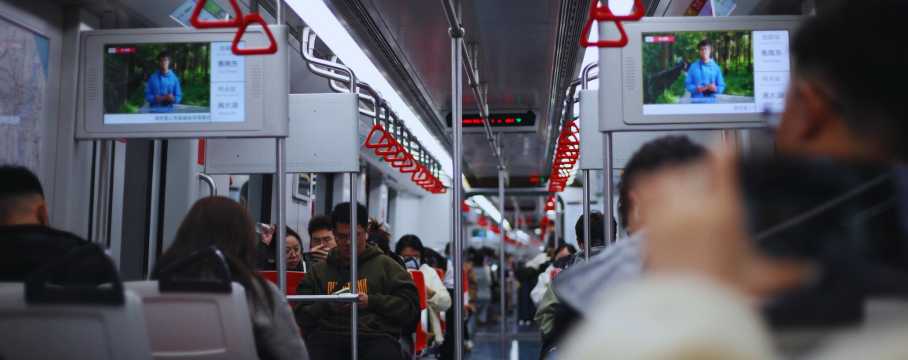 Interior de vagón de metro en Shanghái con pasajeros sentados y pantallas informativas