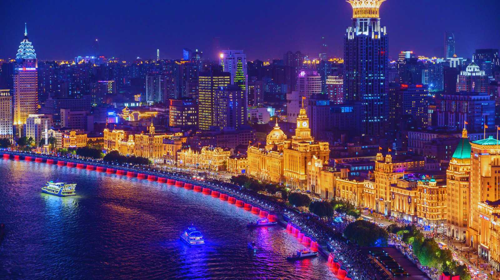 Vista nocturna del Bund en Shanghái, con edificios históricos iluminados junto al río Huangpu