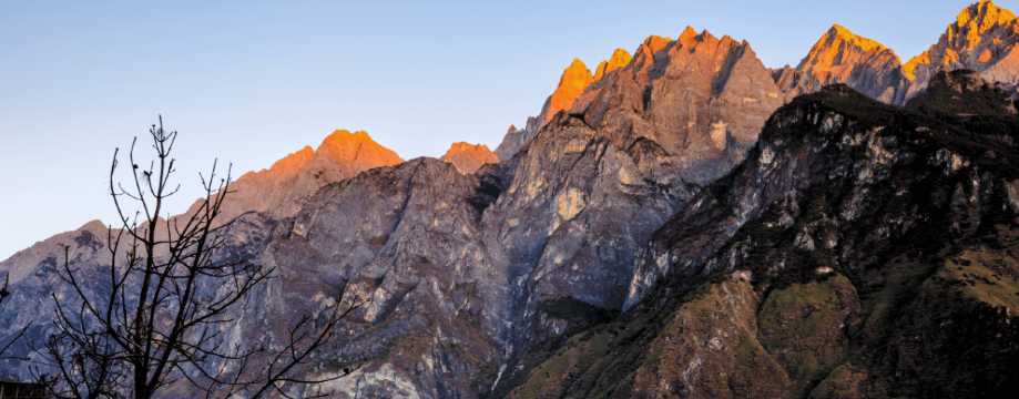 Le montagne della Gola del Salto della Tigre illuminate al tramonto con le loro vette rocciose nello Yunnan.