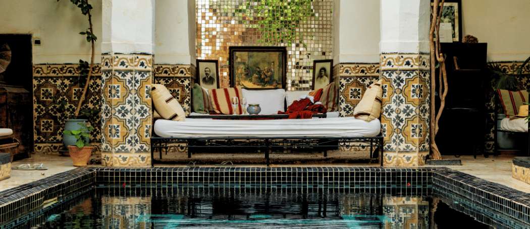 A traditional Riad in Morocco, featuring a beautiful courtyard, a pool, and intricate Moroccan decor.