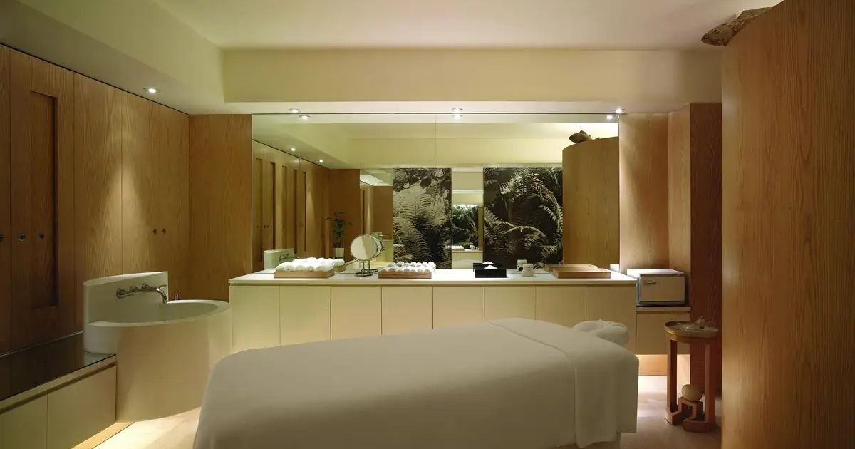 Spa cabin with massage bed, washbasin and warm lighting in a wellness centre in Hong Kong