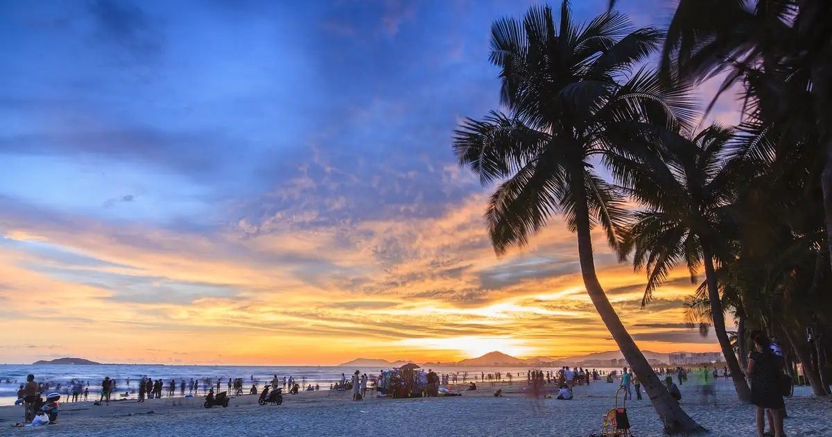Puesta de sol entre palmeras en la playa del Coconut Dream Corridor de Sanya.