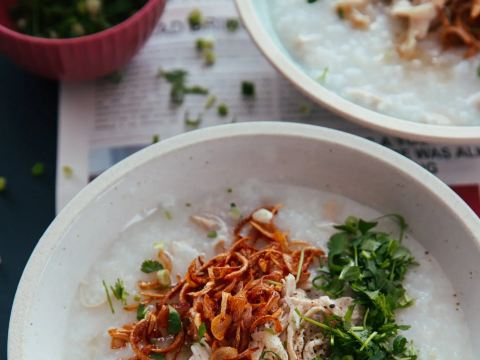 Chinese chicken congee, jirou zhou, topped with crispy fried shallots and fresh herbs