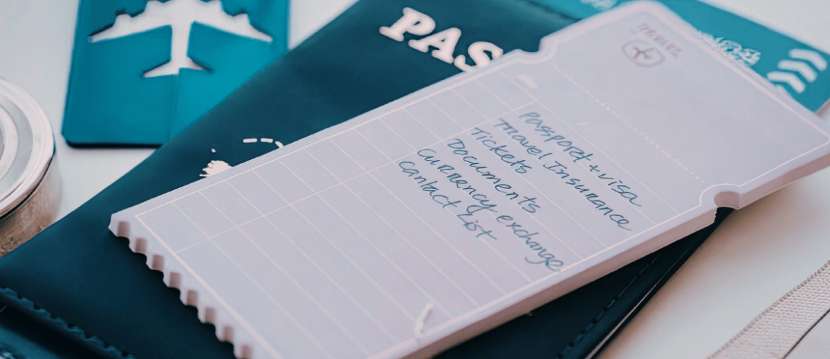 Pasaporte y lista de viaje con documentos esenciales como visa, seguro y billetes de avión