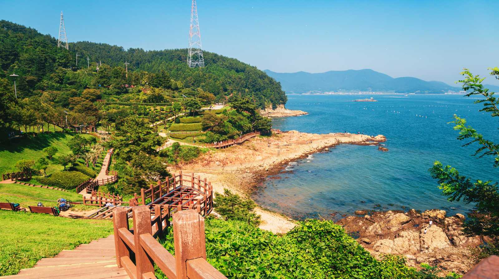 Senderos de madera y zona verde del parque costero Igidae en Busan, con acantilados y vistas al mar