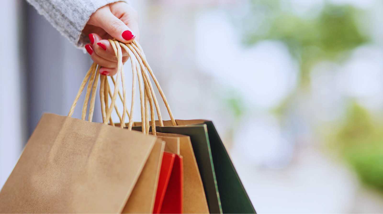 Persona sosteniendo varias bolsas de compras, imagen asociada a ir de compras en la ciudad.