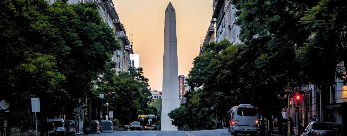 Obelisco de Buenos Aires en una avenida céntrica con tráfico urbano y edificios históricos