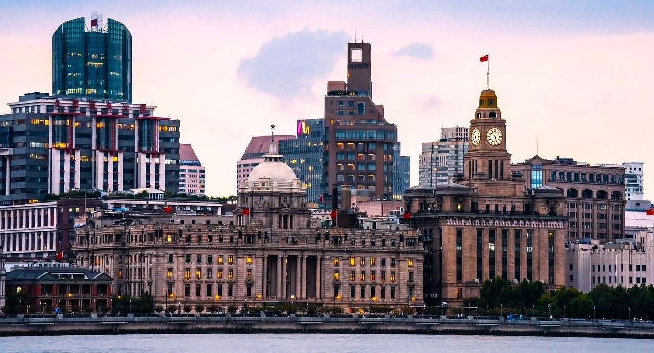 Edificios históricos del Bund en Shanghái junto al río Huangpu con arquitectura colonial y skyline urbano.