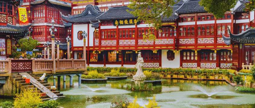 Edificios tradicionales chinos con puentes y estanque en el área histórica de Yuyuan Bazaar en Shanghái.