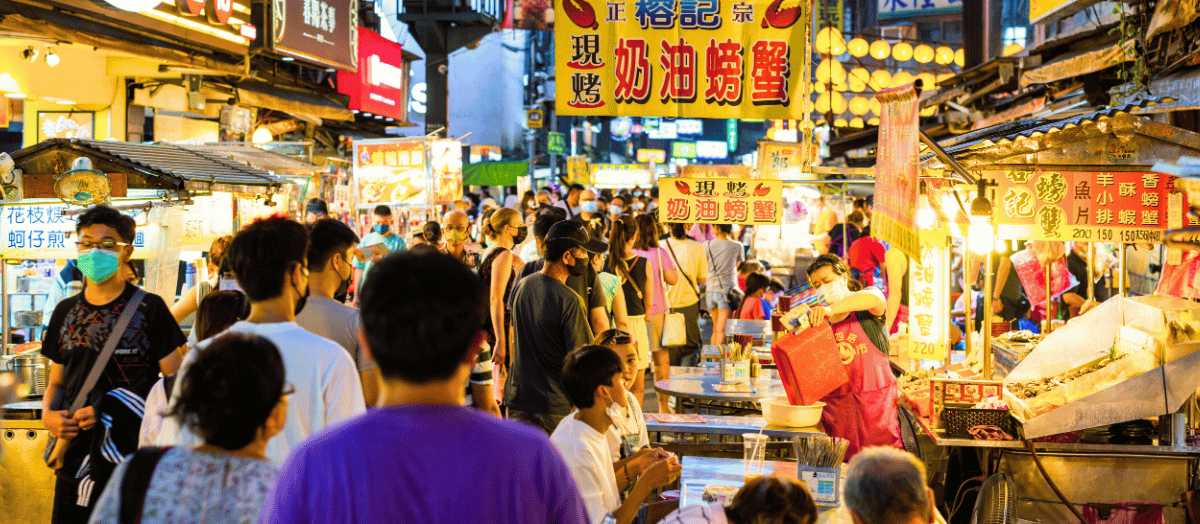 Mercado nocturno de Taiwán lleno de puestos de comida callejera y visitantes