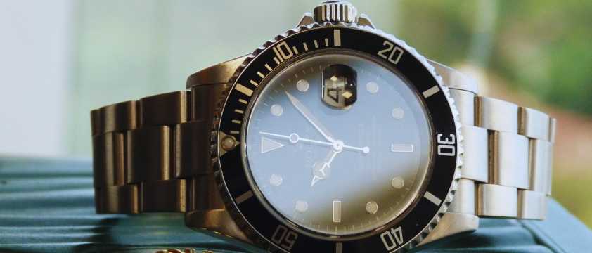 Reloj de acero inoxidable con esfera negra y bisel numerado en primer plano