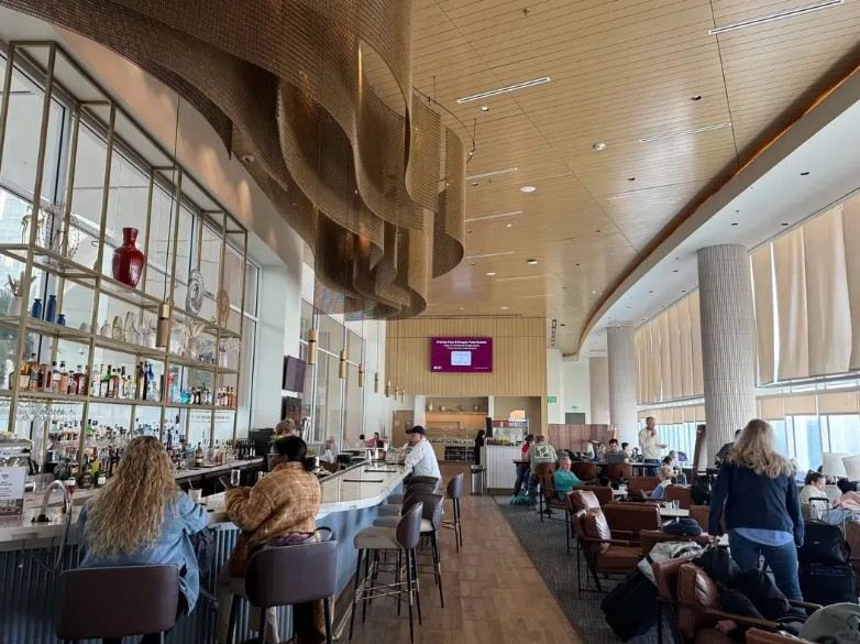 Travelers enjoying a comfortable lounge space inside Orlando International Airport
