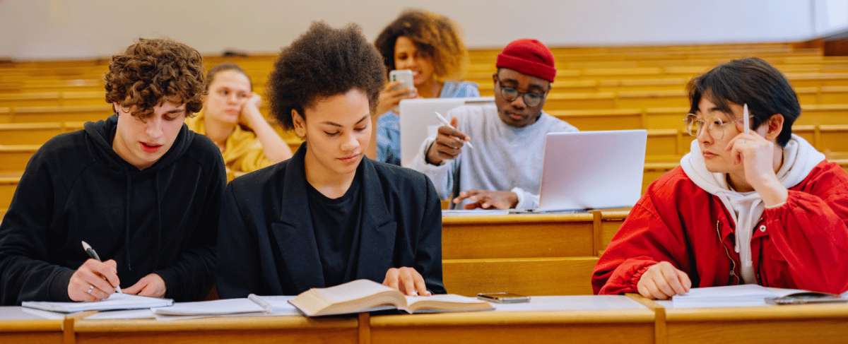 Estudiantes en aula universitaria tomando apuntes durante una clase presencial