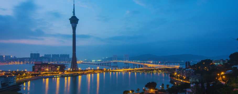 Night-time view of Macau Tower and the illuminated bridge, a stunning cityscape in this Asian destination.
