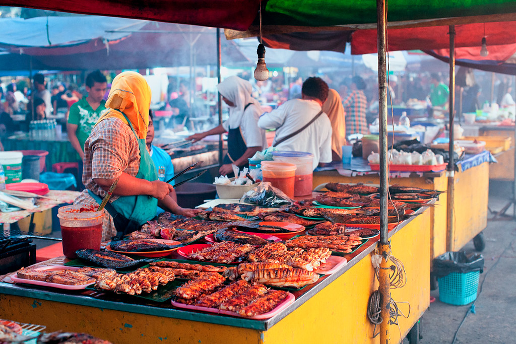 A street food vendor selling an assortment of barbequed foods