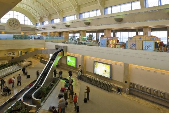 John Wayne Airport interior with travelers and baggage carousel