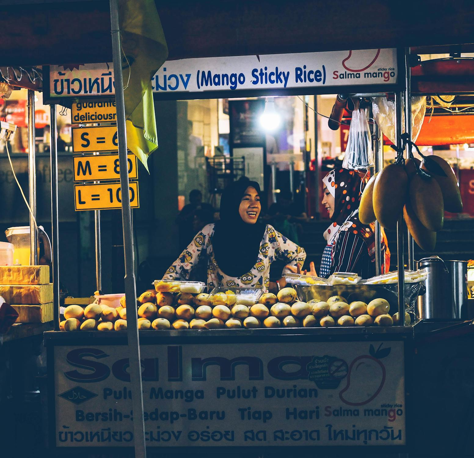 muslim women selling snacks and food by the side of the road