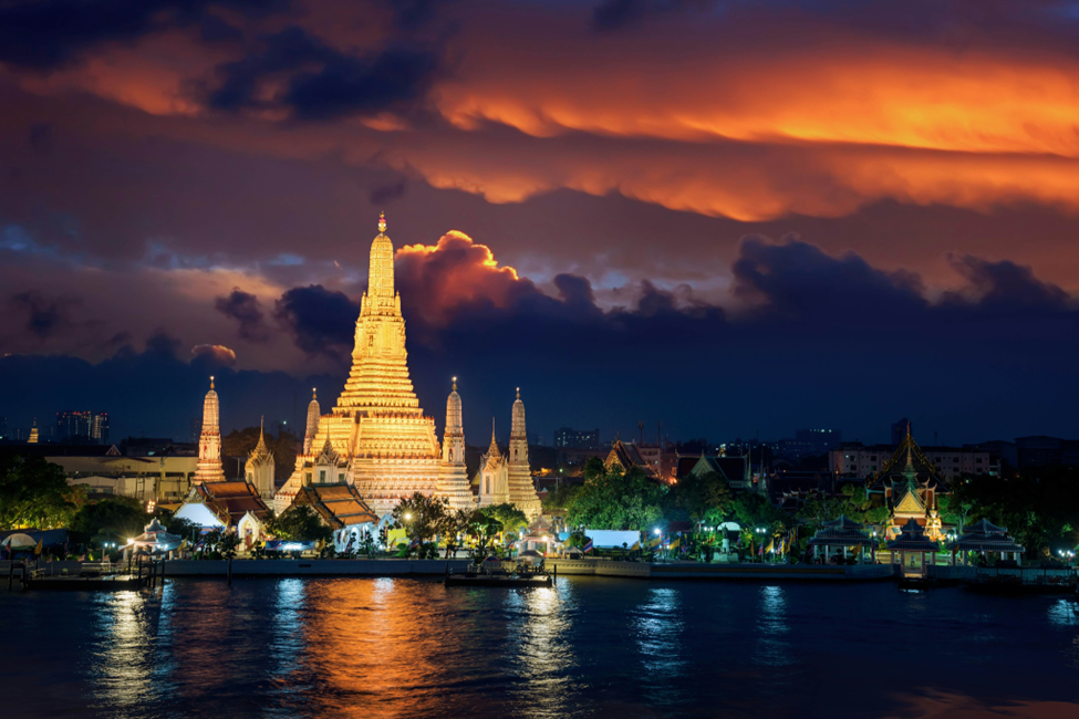 A panoramic view of Bangkok skyline at night, overlooking the river