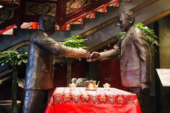 Bronze statues of two men exchanging tea at Lao She Teahouse