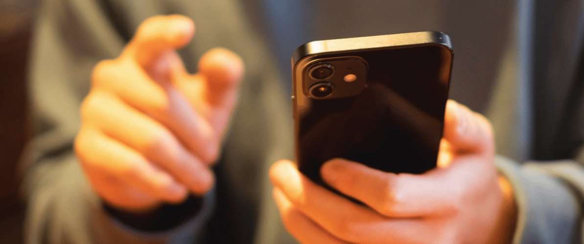 Persona che tiene uno smartphone tra le mani per controllare i social media