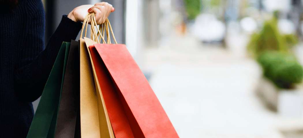 Persona con bolsas de compras en una calle comercial de Asia
