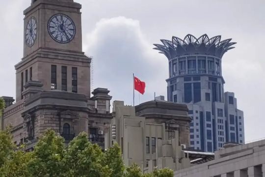 Historic clock tower and modern high-rise building in Shanghai