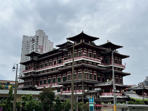 The Buddha Tooth Relic Temple on South Bridge Road in Chinatown, Singapore, with its tiered red roofs and a Housing Board block behind