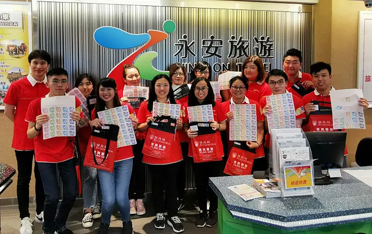 永安旅遊義工同事手持保良局旗袋,為弱勢社群略盡綿力。